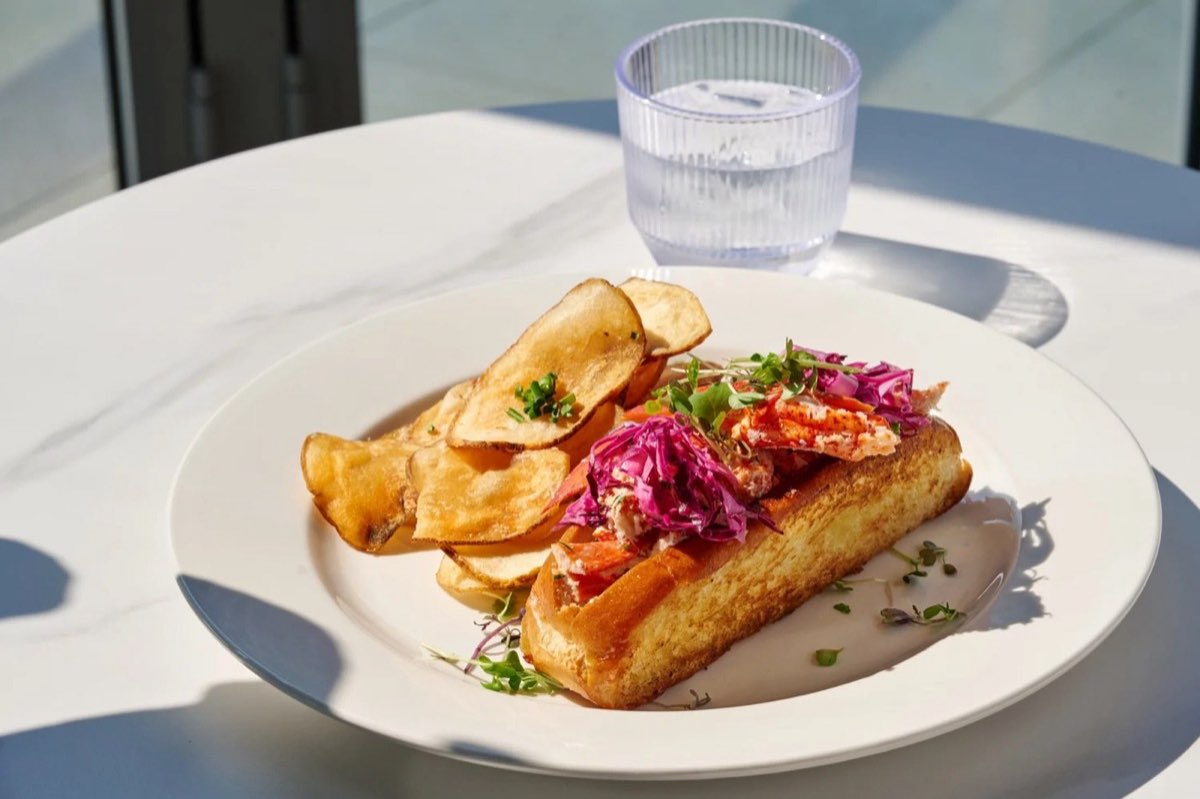 Blue Anchor: lobster roll with chips on an outdoor table. Photo from their website.