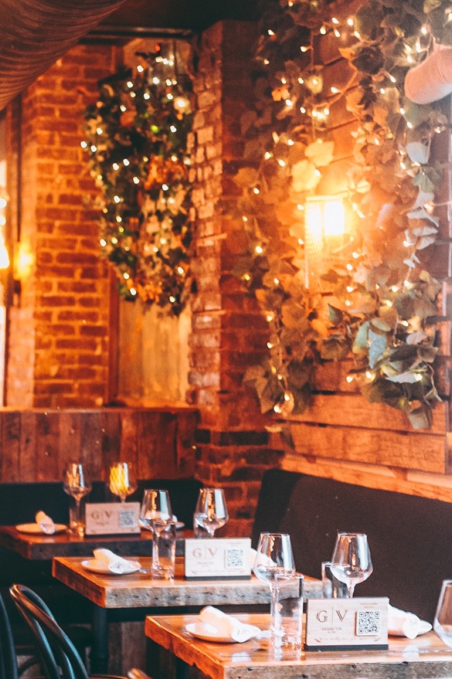 Grand Vin: candlelit dining room with brick wall and string lights. Photo from their website.