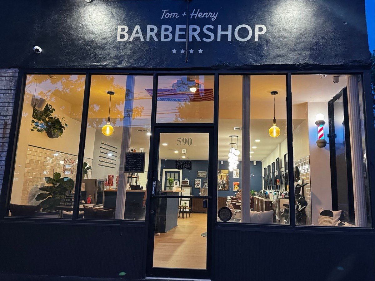 Tom+Henry Barbershop: the barbershop storefront at night. Photo from their website.